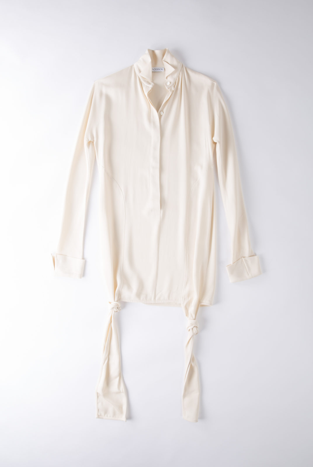 Blouse cream, en tissu double georgette, fluide et féminin, col souple et poignets ouverts, JW Anderson.